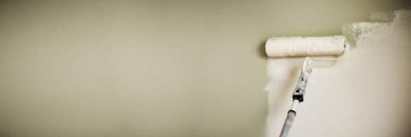 Hand painting wall with paint roller, pastel color. Appartment renovation, repair, building and home concept. Copy space, banner. Tools for painting walls.